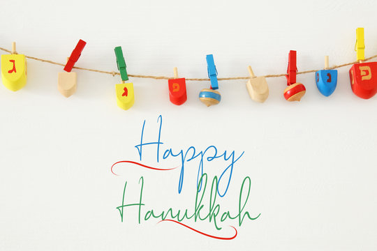 Image of jewish holiday Hanukkah with wooden dreidels colection (spinning top) over white background.