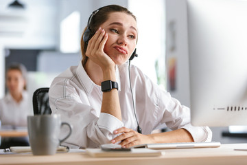 Bored young woman wearing microphone headset