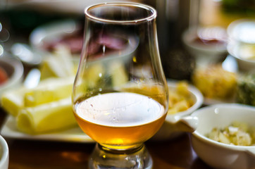 glass of whisky single malt and set with different appetizers in small portions