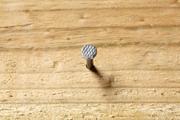 nail fixed in a wooden board