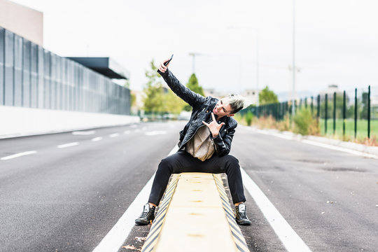 Punk woman taking selfie with smartphone