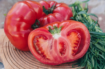 Ripe large pink tomatoes are prepared for cutting into a salad. Vegan food. Healthy diet