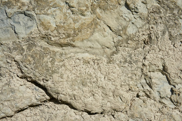 Mountain stone with a natural texture as a design concept. Cracks created by nature on the surface of the stone with a natural color scheme, create a natural textured background. Texture for design .