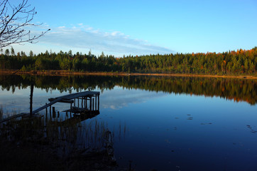 Nature of Sweden in autumn, Calm lake Kolpen with old wooden bridge and forest reflection, Peaceful outdoor image, Along the hiking trail Bruksleden in october