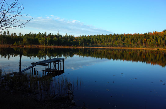 Nature of Sweden in autumn, Calm lake Kolpen with old wooden bridge and forest reflection, Peaceful outdoor image, Along the hiking trail Bruksleden in october © art_of_line