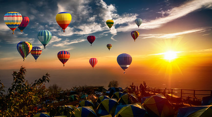 Dramatic panorama of mountain with hot air balloons at sunset,Thailand.