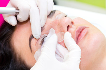 Woman on the procedure for eyelash extensions, eyelashes lamination 