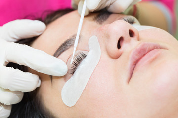 Woman on the procedure for eyelash extensions, eyelashes lamination 