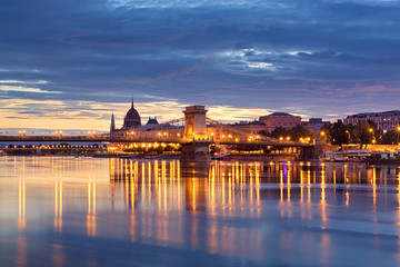 Night view of Chain bridge and illuminated Budapest downtown reflecting in the river