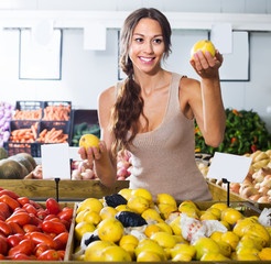Obraz premium Young woman customer choosing lemons