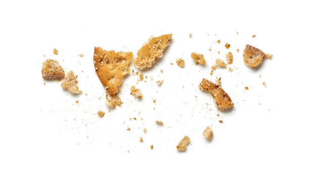 Scattered crumbs of cookie or cracker isolated on white background. Top view.