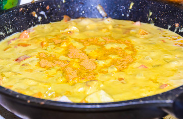 cooking yellow curry in a saucepan skillet many spices spicy chicken