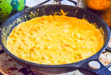 cooking yellow curry in a saucepan skillet many spices spicy chicken