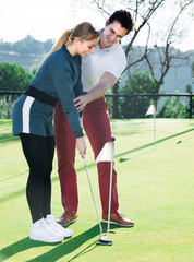Obraz premium Young man is training female to play golf