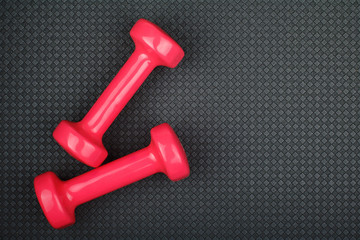 Dumbbells on yoga mat with copy space text, top view