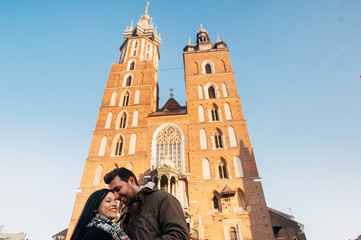 Attractive couples cuddling with cathedral on background