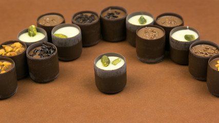 Chocolate candy laid out on a brown background. Luxury expensive candy laid out on a dark brown background.