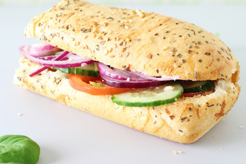 sandwich baguette sesame vegetables on a light background