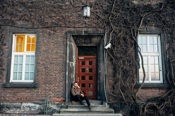 Attractive man with a beard sit on the stairs
