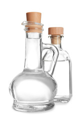 Glass jug and bottle with vinegar on white background