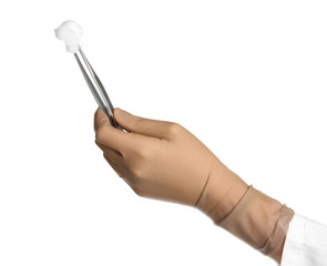 Doctor in sterile glove holding medical forceps with cotton ball on white background