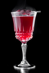beautiful burgundy red cocktail in a beautiful glass isolated on a black background. close up. dark background