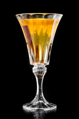 beautiful yellow cocktail in a beautiful glass isolated on a black background. close up. dark background