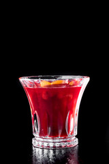 Hot wine Cocktail isolated on black. mulled red wine, in a beautiful glass, with spices on dark