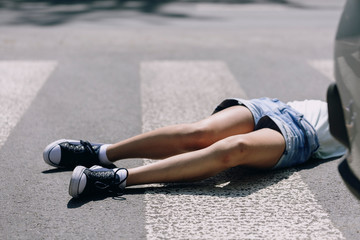 Kid hit by a car lying on a crosswalk after traffic accident - obrazy, fototapety, plakaty