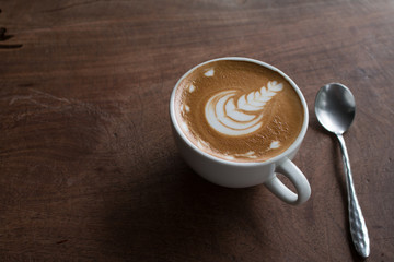 Close up of Cup of hot latte art coffee on wooden table