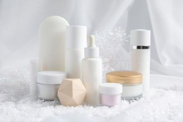 Obraz na płótnie Canvas Set of cosmetic products and decorative snow on white fabric. Winter care