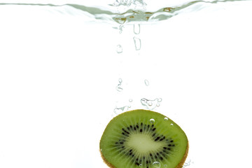 Slices of kiwi rings thrown into the water. View from under the water