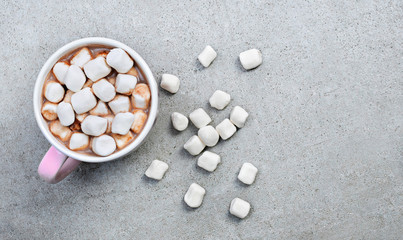 Hot chocolate or cocoa drink in a cup or mug. Top view of hot chocolate with marshmallows on a concrete stone background.