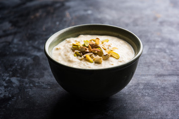 Sweet Rabdi or Lachha Rabri or basundi, made with pure milk garnished with dry fruits. Served in a bowl over moody background. Selective focus
