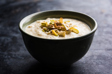 Sweet Rabdi or Lachha Rabri or basundi, made with pure milk garnished with dry fruits. Served in a bowl over moody background. Selective focus