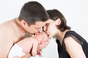 young father mother parents kisses his sleeping newborn son. mummy daddy and newborn baby closeup