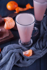 Cocoa and tangerines on a dark wooden background
