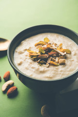 Sweet Rabdi or Lachha Rabri or basundi, made with pure milk garnished with dry fruits. Served in a bowl over moody background. Selective focus