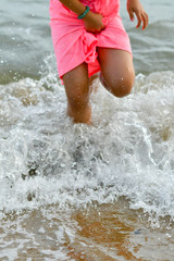Fototapeta premium Asian girl with pink dress playing by the seaside