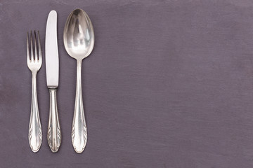 silver cutlery on a gray plate