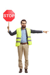 Man with a safety vest holding stop sign and pointing