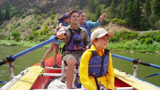 Happy Caucasian family rafting on Colorado River on vacation outdoors