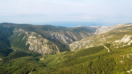 Aerial view of stone mountains with forest in Croatia and sea background
