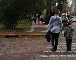 Padre e hijo cruzando la calle en la ciudad