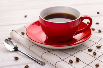 Coffee cup and coffee beans on white wooden background