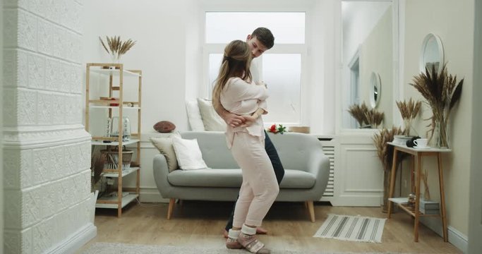 Sweet coup at home dacing in the living , home wearing clothes , cozy atmosphere.