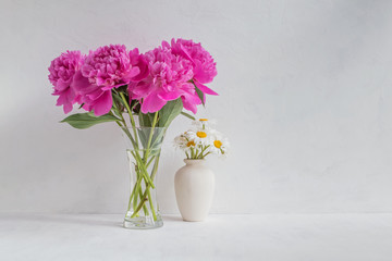 Pink peonies in a vase on a light background