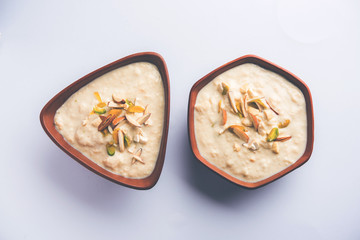 Sweet Rabdi or Lachha Rabri or basundi, made with pure milk garnished with dry fruits. Served in a bowl over moody background. Selective focus
