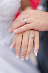 wedding rings on hands of newlyweds