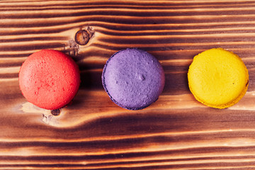 Cake macaron or macaroon on wooden background from above, colorful almond cookies, top view